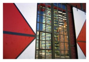 Das Colorium im Düsseldorfer Medienhafen, gespiegelt in einem Fenster des Port Event Centers
